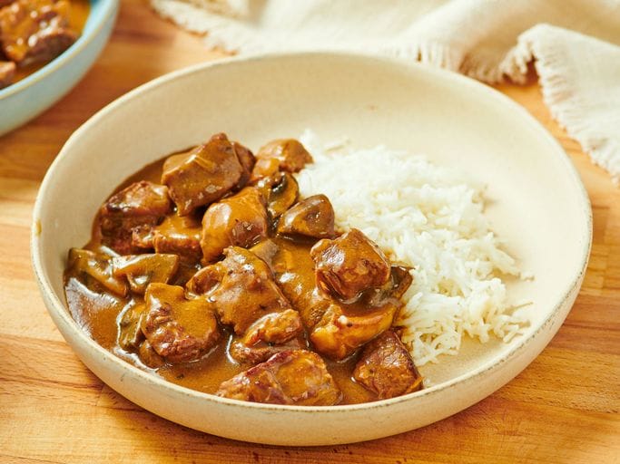 tender beef tips in rich brown gravy served over fluffy white rice in a homemade comfort food bowl.