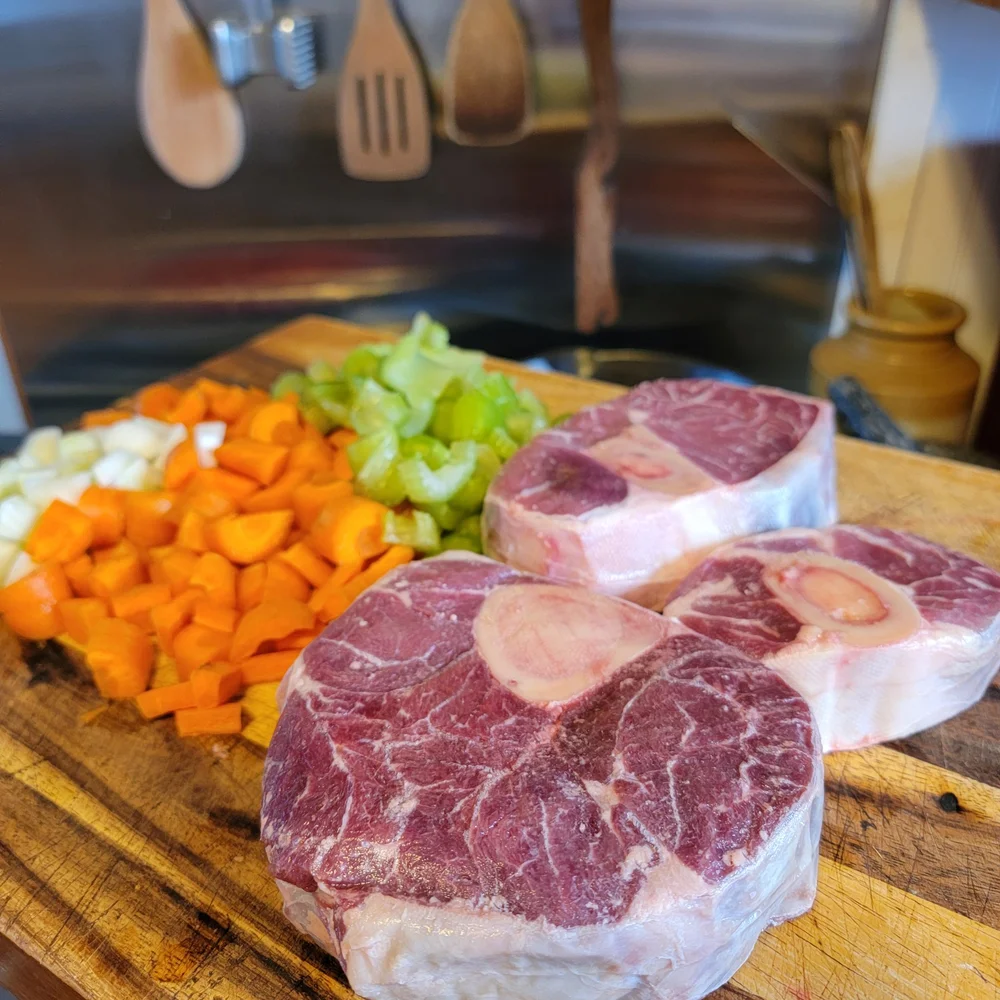 Raw beef shank cross cut pieces with visible bone marrow on a cutting board ready for slow cooker cooking