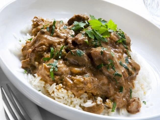 homemade beef tips and rice with tender beef pieces in thick brown gravy served over fluffy white rice