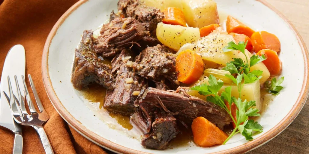 Slow cooker beef chuck roast with tender beef, potatoes, carrots, and rich gravy