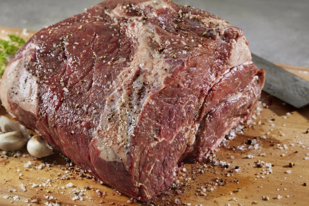 Slow cooker Italian beef sandwich with shredded beef, pepperoncini peppers, and melted provolone on a toasted hoagie roll